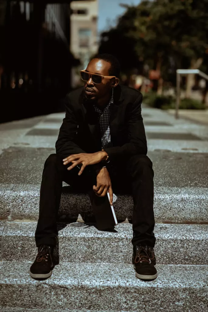David sitting on city steps with a notebook in his hand